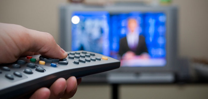 Person changing channel with remote
